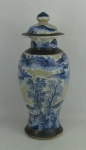 Potiche em porcelana oriental, decorado com paisagem de casas, montanhas e arvores em azul. Apresenta marca na base. Manchas causadas pelo tempo e tampa com pequena colagem e lascado na borda. Alt. 34,5cm.