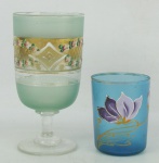 Duas peças de coleção em vidro, sendo taça e copo na cor azul, decoradas com pintura floral em policromia e detalhes em dourado. Alts. 12,5 e 7cm.