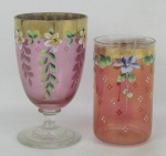 Duas peças de coleção em vidro na cor rosa, sendo taça e copo, decorados com pintura floral em policromia e detalhes em dourado. Alts. 12 e 9,5cm.