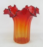 Vaso em murano no tom vermelho degrade, trabalhado com gomos em relevo e borda com recortes. Apresenta pequena batida na base. Alt. 28cm.