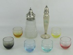 a) Dois saleiros em prata inglesa contrastada, tendo um recipiente em cristal lapidado e o outro na forma de sinete, tendo este enchimento na base. Pratas com mossas e recipiente em cristal com mofo na parte interna. Alts. 15 e 16,5cm. b) Seis copinhos coloridos em cristal tcheco, com marca da manufatura Moser na base. Alt. 4,5cm.