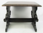 Mesa de apoio em madeira nobre entalhada. Tampo retangular com trabalhos em baixo relevo  na aba. Laterais com detalhes de folhas e volutas, unidas por um travessão central. Marcas de uso. Med. 44,5x61x35 cm.