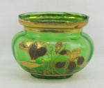 Floreira em vidro veneziano no tom verde, decorada com pintura de flores e folhagens em dourado e com toques de esmalte. Apresenta assinatura e numeração na base. Borda com três minúsculas batidinhas. Med. 13,5x18,5x14,5cm.