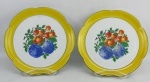 Par de pratos em porcelana alemã, com marca da manufatura Wurttemberg no verso. Abas no tom amarelo e ao centro folhas e frutas em policromia. Diam. 21cm.