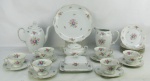 Aparelho para chá em porcelana polonesa com marca da manufatura KPM no verso, com decoração floral em policromia, composto de bule, leiteira, açucareiro, manteigueira, prato para bolo, 6 pratos para sobremesa e 6 xícaras. Bico do bule com restauro. Total 17 peças. Alt. bule 21cm.