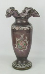 Vaso em vidro na tonalidade lilás, decorado ao gosto veneziano, com pintura floral em policromia e arabescos na cor branca. Borda ondulada em babados. Alt. 32cm.
