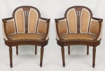Elegante par de poltronas, estilo Luis XVI, em madeira entalhada com folhagens e gomos. Encosto e laterais com tecido. Assento em palhinha. Pernas torneadas e frisadas. Med. 85,5x69,5x42cm.