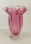 Vaso em grosso cristal europeu, na tonalidade doublet rosa e translúcido, trabalhado em retorcidos. Borda ondulada em babados. Alt. 29,5cm.