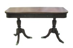 Mesa console em madeira entalhada. Tampo de abrir sobre 2 gavetas com puxadores em bronze, sustentado por 2 colunas que se apoiam a 3 pernas recurvas, terminando com pés em garra, em bronze. Marcas de uso. Med. aberta 76,5x140x101cm e med. fechado 76,5x140x50,5cm.