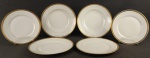 Limoges - Conjunto de 6 pratos em porcelana francesa, com marca da manufatura, sendo 2 rasos, 2 fundos e 2 para sobremesa, decorados na borda com faixa dourada com trabalhos de gregas em relevo. Diamts. 25, 24,5 e 22cm.