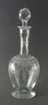 Licoreiro bojudo em cristal francês, Saint Louis, lapidado com guirlandas, flores e folhagens em satiné. Tampa em facetas. Alt. 30,5cm.