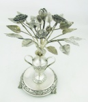 Paliteiro de coleção, em prata contrastada, na forma de vaso com flores, folhas e pássaro. Galhos com solda. Alt. 20,5cm. Peso 440g.