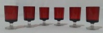 Conjunto de tacinhas em cristal francês na tonalidade vermelha e pés translúcidos, contendo 6 unidades. Medida altura 7 e diâmetro da boca 4 cm.