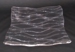 Centro de mesa em cristal, com formato quadrado e lapidação ondulada. Medida do lado 30 cm.