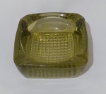 Cinzeiro para charuto em cristal prensado, com formato quadrado, na tonalidade amarela, com lapidação embaixo estilo bico de jaca. Medida altura 6 cm e lados 15 cm.