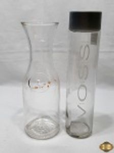 Lote composto de jarra em vidro incolor e garrafa em vidro da Voss. Medindo a garrafa 29,5cm de altura.