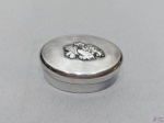 Pequena caixa oval em prata de lei 800, com relevo na tampa. Medindo 5cm x 3cm x 2cm de altura, pesando 15 gramas.
