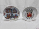Lote de 2 pratos decorativos em porcelana, sendo um com estampa do brasão da Cidade de Viseu e um com monumentos de Paris. Medindo 24,5cm de diâmetro.