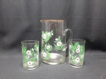 Jogo de jarra com 2 copos em vidro com pintura floral à mão. Medindo a jarra 19cm de altura e os copos 10,5cm de altura.