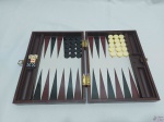 Jogo de gamão com caixa de madeira revestida em couro e peças em resina. Medindo 33,5cm x 22,5cm.