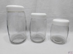 Jogo de 3 potes para condimentos em vidro com tampa em plástico. Medindo o maior: 23,5 cm de altura.