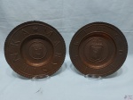 Lote de 2 medalhões em cobre martelado com imagem de brasão. Suporte de mesa não incluso. Medindo: 24,5 cm de diâmetro.