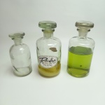 RASTRO - 3 Antigos frascos de perfume com tampas de vidro, contém resíduo de perfume, não apresenta trincas ou bicados, vendidos no estado conforme fotos. Medem 18 cm de altura por 8 cm de diâmetro.