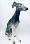 Escultura Cão da raça Galgo, confeccionada em faiança, na cor cinza. Med. 44x33 cm.