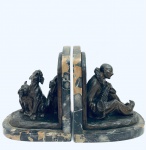 Rico Par de Serre Livres adornado por duas esculturas em bronze, representando Pierrot tocando instrumento e três cães uivando ao ouvir a canção. Bronze assinado L. Fontinelle (1886-1964), sobreposta por mármore nero portoro. Med. 22x18x15 cm.