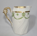 Belíssima Leiteira em fina porcelana Francesa Vieux Paris em tom branco com laçarotes em tom verde e detalhes a ouro. Dimensões: 14x13 cm.