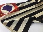 MILITARIA - Belíssima bandeira paulista em seda/cetim, antiga (fora das proporções oficiais) e fabricada em uma antiga estamparia de Curitiba. A peça está em ótimo estado de conservação, apesar de pequenos furos e marcas do tempo. Apresenta ainda carimbo original do fabricante. Anos 40, medindo 47 x 64cm, tamanho perfeito para exposição.