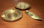 METAL DOURADO. LOTE COMPOSTO POR TRÊS CINZEIROS DE DIFERENTES FORMATOS E ORIGENS.