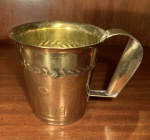 METAL DOURADO. GRANDE CANECA MARTELADA COM MOTIVO FITOMORFO. ORIGEM; TURQUIA. MEDIDAS; 12,4 X 17.