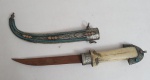 Adaga arabe com lâmina em aço carbono, com cabo em osso com apliques em metal e bainha  banhada a prata ricamente cinzelado decorado com arabescos , med. 42 centímetros.