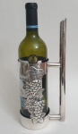 Belo suporte para servi vinho em prata 90, peça com longa pega e decorada com cacho de uvas em alto relevo, med. 28 x 12 centímetros.