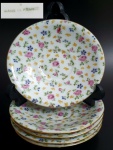 Cinco pratos em porcelana francesa, decorados com flores coloridas e folhas, med. 14 centímetros de diâmetro.
