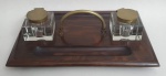 Elegante tinteiro, peça com base em madeira maciça, recipientes em cristal e tapas e pega em bronze,  med. 9 x 40 x 21 centímetros. ( um dos recipientes apresenta bicados na base)