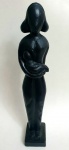Escultura em madeira maciça, peça representando mãe e bebê, na cor preto, med. 43 centímetros.