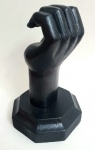 Escultura em madeira maciça, peça representando punho entre aberto, na cor preto, med. 22 centímetros.