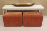 Dois puffs em formato retangular, forrado em tecido sued na cor grená, med. 40 x 60 x 37 centímetros cada.