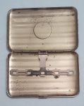 Cigarreira em metal dourado com roleta aplicada na tampa,  med. 13 x 8 centímetros.