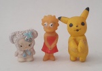 Três antigos bonecos em borracha,  sendo a gatinha hello kitty,  a Lisa Simpson e o Pokémon Pikachu, o maior med. 8 centímetros.