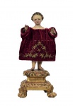 Imaginária de madeira esculpida e policromada , representada pelo menino Jesus dito Colonial sobre pedestal dourado. Olhos de vidro. Acompanha caixa com 13 roupinhas de época , confeccionados em convento. Brasil - Bahia - Século XIX. Med. 26 x 11 x 11 cm (medidas totais);  10x 18 x 31 cm (caixa roupinhas). roupinhas :  10 x 15 cm (maior); 12 x 12 cm (menor) . Marcas do tempo com desgastes e pequenas perdas. As roupinhas estão no estado. Coleção particular Rio de Janeiro/RJ.