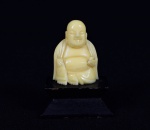 Arte Oriental -  Pequena escultura de marfim representado "Budha Sorridente". Base de madeira ebanizada.  Marcas do tempo. Med. 6 x 3 x 4,5 cm (medidas totais); 4 x 3 2 cm (Budha). Acervo Particular São Paulo/SP.