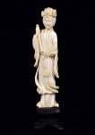 Arte Oriental -Escultura de marfim representando gueixa segurando elementos não identificados. Base de madeira. Marcas do tempo. Pequenas faltas. Med. 14 x 3 x 2,5  cm (medidas totais); 11,5 x 2,5 x 1,5 cm (escultura). Acervo Particular São Paulo/SP