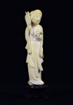 Arte Oriental -Escultura de marfim representando gueixa segurando flor e outro elemento não identificado. Base de madeira. Marcas do tempo. Pequenas falta na base. Med. 15 x 5 x 3 cm (medidas totais); 13 x 3,5 x 2 cm (escultura). Acervo Particular São Paulo/SP