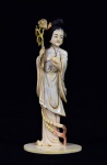 Arte Oriental -Escultura de marfim policromado representando gueixa segurando fruto e ramo de flores. Marcas do tempo. Desgastes. Med. 14 x 6 cm Acervo Particular São Paulo/SP