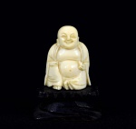Arte Oriental -  Pequena escultura de marfim representado "Budha Sorridente". Base de madeira ebanizada.  Marcas do tempo. Med. 6 x 4 x 3 cm (medidas totais); 4 x 3 x 2 cm (Budha). Acervo Particular São Paulo/SP.