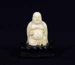 Arte Oriental -  Pequena escultura de marfim representado "Budha Sorridente". Base de madeira ebanizada.  Marcas do tempo. Med. 5 x 4 x 3 cm (medidas totais); 4 x 2,5 x 2 cm (Budha). Acervo Particular São Paulo/SP.