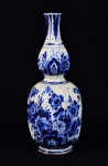 DELFT - Importante vaso em faiança holandesa de "Delft" ao gosto do padrão Séc XVIII,   dito "double gourd" . Presença de nervuras em toda a sua extensão. Profusamente decorado em azul com a temática floral. Hollanda - Sé XX. Marcas no verso com a marca da fábrica Royal Delft. Datável de 1945 (BO). Med. 39 x 16 cm de diâmetro. Presença de craquelê. Acervo particular - espólio Léa Schmitt Leal.